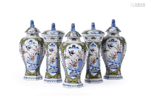A DUTCH DELFT POLYCHROME GARNITURE OF FIVE VASES AND COVERS,...