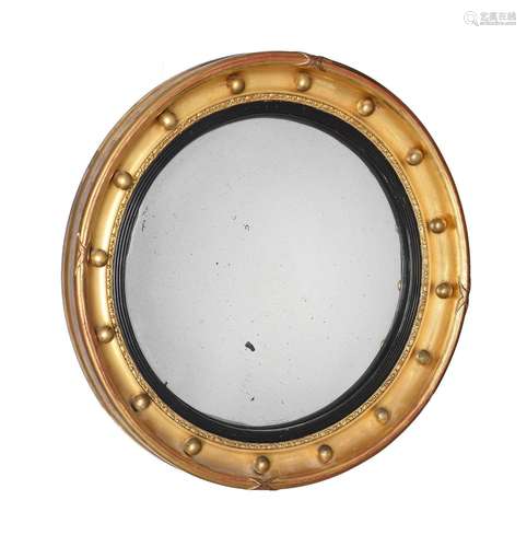 A REGENCY GILTWOOD CONVEX WALL MIRROR, IN THE MANNER OF THOM...