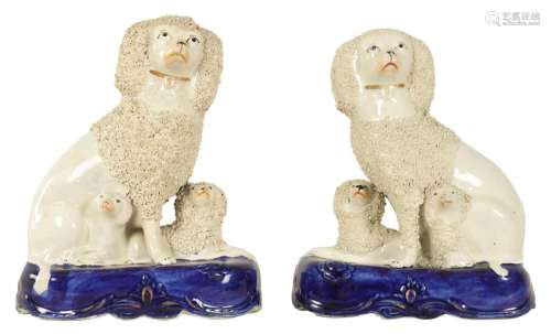A PAIR OF 19TH CENTURY STAFFORDSHIRE SEATED POODLE DOGS WITH...