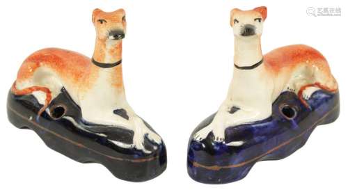 A PAIR OF 19TH CENTURY STAFFORDSHIRE RECUMBENT HOUNDS