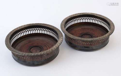 A pair of reproduction silver plated wine bottle coasters, m...
