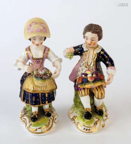 A pair of antique continental porcelain statues of a young m...