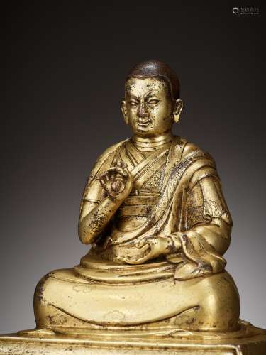 AN INSCRIBED GILT BRONZE FIGURE OF A LAMA, 17TH-18TH CENTURY