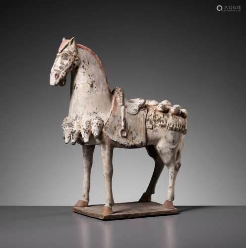A PAINTED POTTERY FIGURE OF A CAPARISONED HORSE, EASTERN WEI...