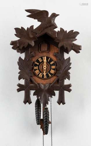 A German Cuckoo twin weight wall clock with carved leaves an...