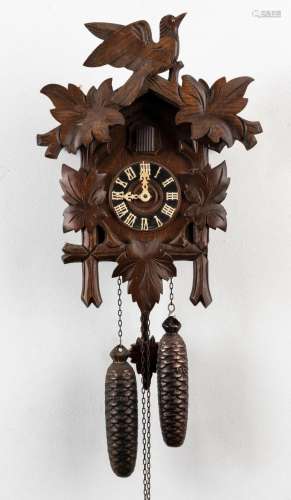 A German Cuckoo twin weight wall clock with carved leaves an...