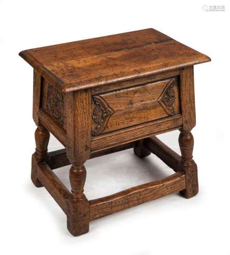 An antique English tapering oak stool with carved panels and...