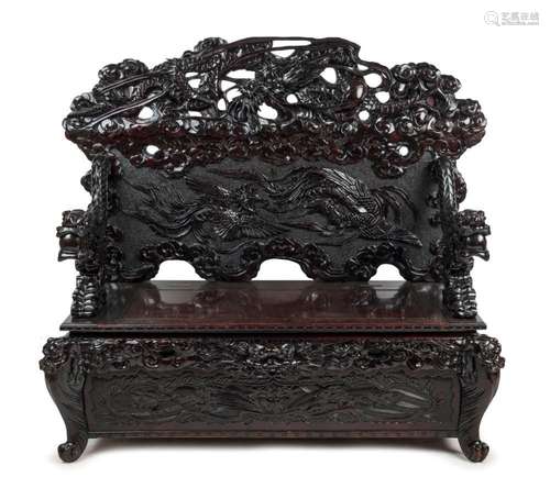 An antique Chinese settle with ebonised finish, impressively...