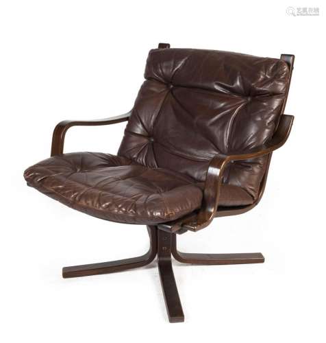 A Scandinavian armchair upholstered in chocolate leather wit...