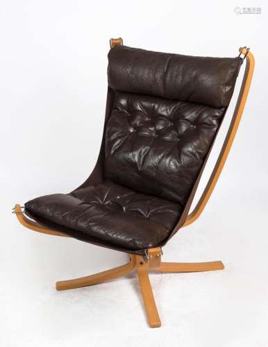 A vintage Scandinavian brown leather easy chair with blond t...