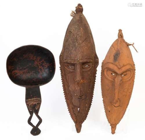 Two tribal masks and a food bowl, carved wood with ochre and...