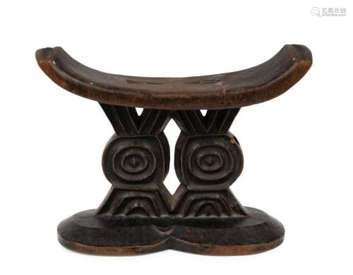 An early headrest, carved wood with faint remains of painted...