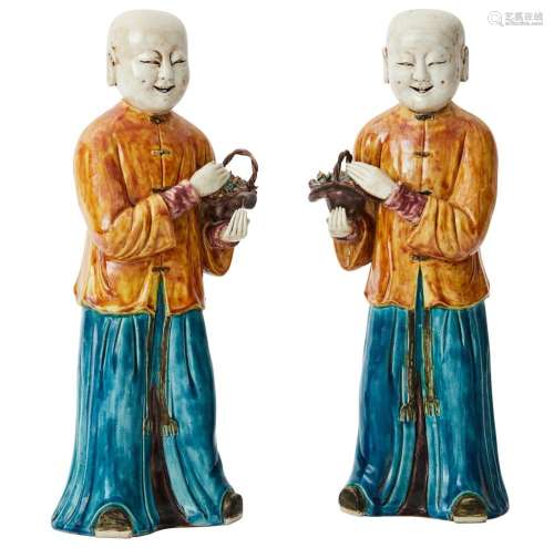 A PAIR OF CHINESE PORCELAIN FIGURES OF LAUGHING BOYS HOLDING...