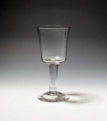 A glass goblet c.1750, the deep bucket bowl raised on a thic...