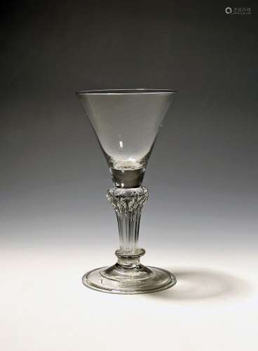 A wine glass c.1730, the funnel bowl rising from an eight-si...