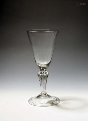 A large glass goblet c.1740, the deep rounded funnel bowl ra...