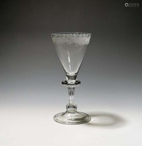 A wine glass c.1740, the funnel bowl engraved around the rim...