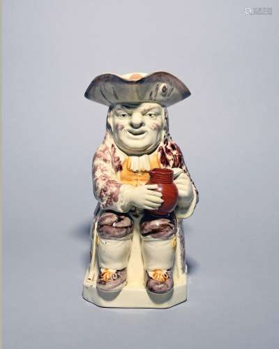 A creamware Wood type Toby jug c.1785-90, seated with an emp...