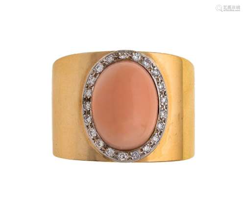 A coral and diamond ring, centring on an oval coral cabochon...