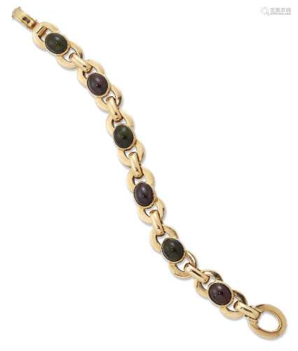 A gold bracelet, of circular linking accented with cabochon ...