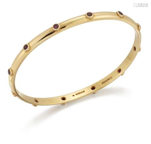 Theo Fennell, an 18ct gold and ruby bangle, inset with circu...