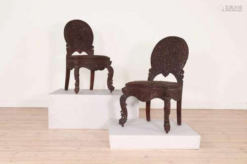 A pair of carved teak chairs,