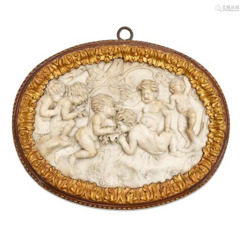 AN ITALIAN CARVED MARBLE OVAL DEPICTING BACCHIC PUTTI