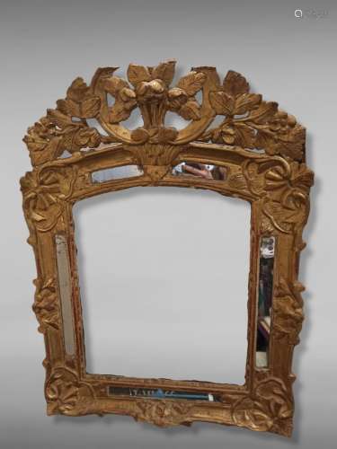 Miroir à parecloses en bois sculpté et doré à décor de fleur...