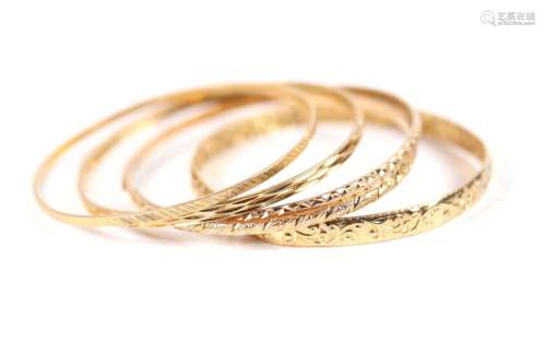 Cinq bracelets joncs en or gravé. Travail étranger (750). Po...