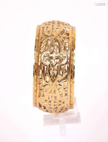 Bracelet rigide ajouré en or jaune (750) à décor de rinceaux...