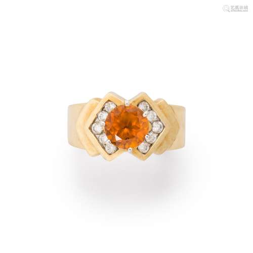 An orange sapphire, CZ and ten karat gold ring