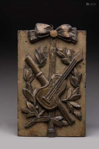 PANNEAU décoratif en bois sculpté et doré à décor d'instrume...