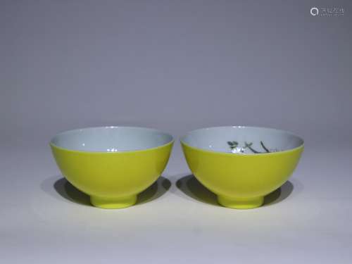 A pair of small bowls with lemon yellow glaze inside
