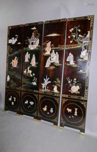 A Chinese lacquered four panel screen with painted and appli...