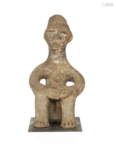 Statuette masculine Igbo souriant, en position assise, terre...