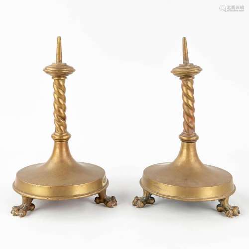 A pair of candlesticks made of bronze, standing on claw feet...