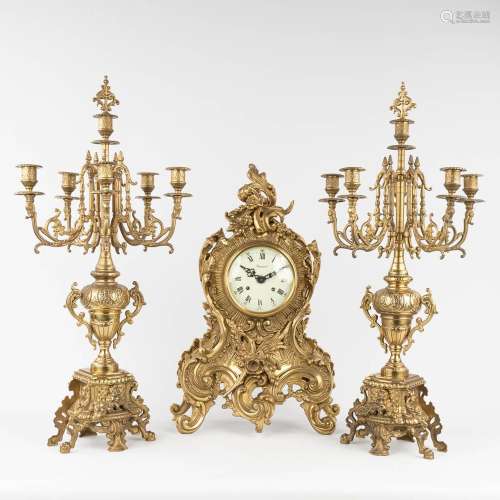 A three-piece mantle garniture clock with candelabra, bronze...