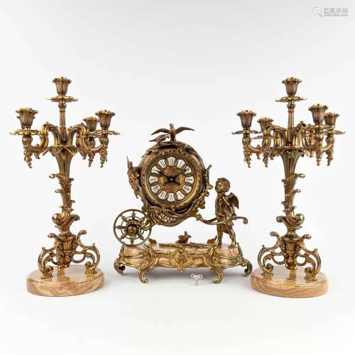 A three-piece mantle garniture clock and candelabra, made of...