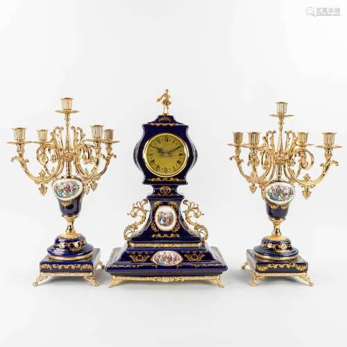 A three-piece porcelain mantle garniture clock and candelabr...