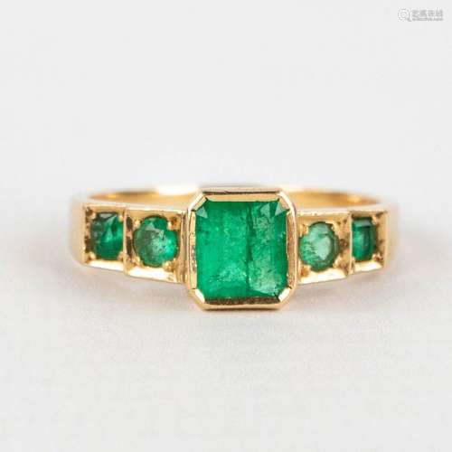 An antique ring with green (semi-)precious stones in a yello...