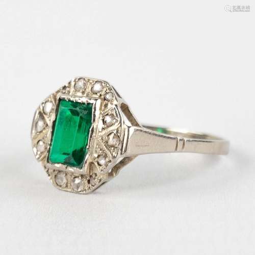 An antique ring with green (semi-)precious stone in a white ...