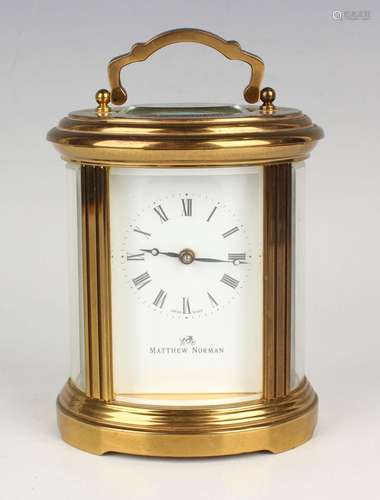 A late 20th century gilt brass oval cased carriage timepiece...