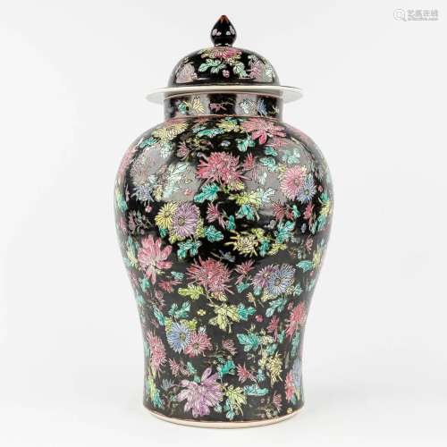 A Chinese 'Famille Noir' vase with lid and floral decor. 20t...
