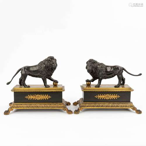 A pair of lions on a stand, made of patinated and gilt bronz...