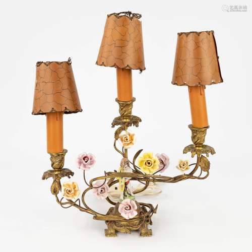 A table lamp, bronze, with porcelain figurine and flowers. P...