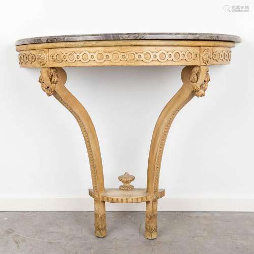 An antique wall console with a marble top, decorated with wo...