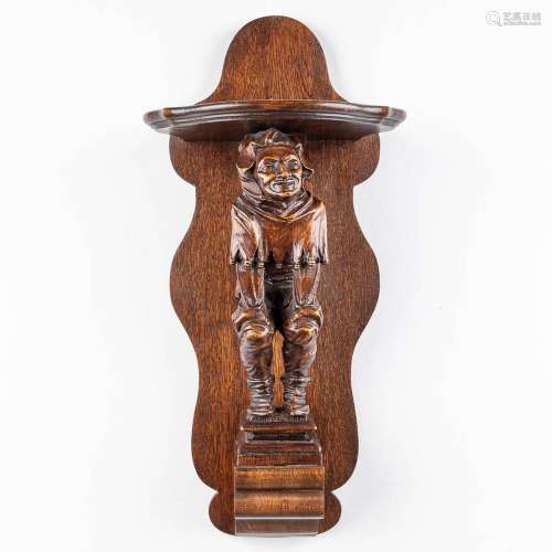 A large wood-sculptured wall console with a Jester figurine....