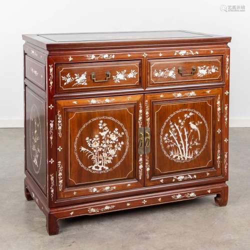 An Oriental commode decorated with mother of pearl inlay. (L...