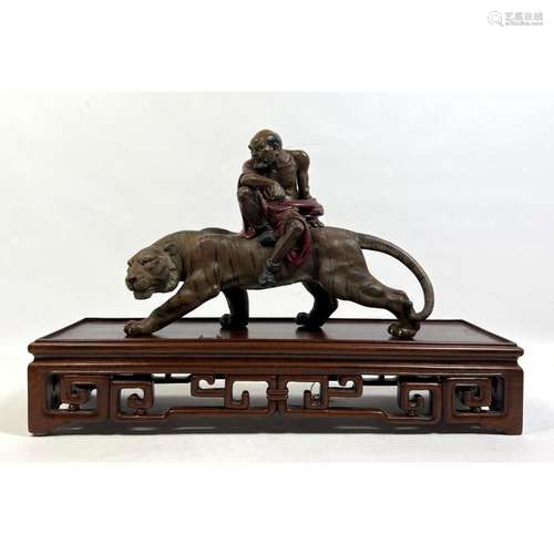 CHINESE FIGURAL SCULPTURE. BEARDED MAN SITS ON TIGER. CARVED...