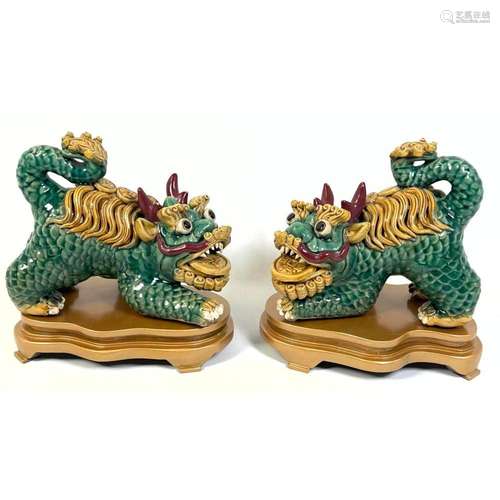 PAIR CHINESE PORCELAIN FOO DOG FIGURES WITH WOOD STANDS.